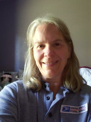 Melissa Pauke smiles for a photo in her USPS uniform.