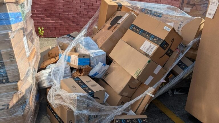 Packages pile up, unsecured and exposed to the elements, outside Harvest post office